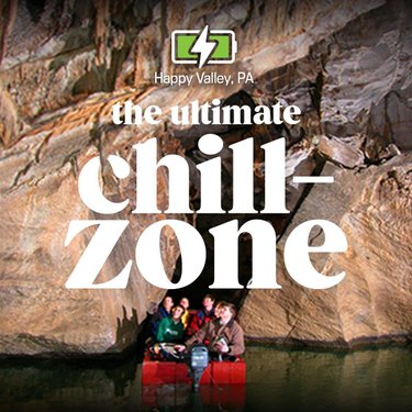 A group of five people in a red boat inside a rocky cave, surrounded by textured stone walls. Text overlay reads "the ultimate chill-zone."