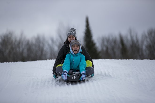 Young kids tobogganing in Ontario during March Break. 