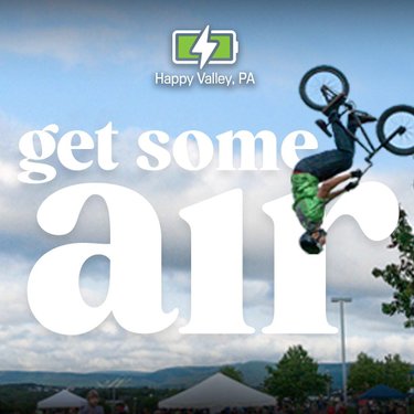 A BMX rider performs a trick mid-air against a backdrop of a cloudy sky and green hills, with promotional text overlaying the scene.