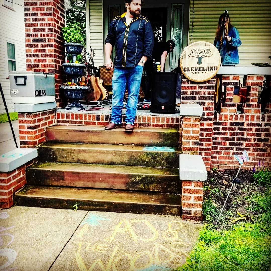 Photo by user ajandthewoods, caption reads What a blast we had larchmereporchfest yesterday! Thanks to everyone that braved the rain!...📸zachdrummer clevelandwhiskey #cle #cleveland #Ohio #PorchFest #festival #whiskey #acousticguitar #porch #summer #rain #rootsrock #ajandthewoods #ajatw